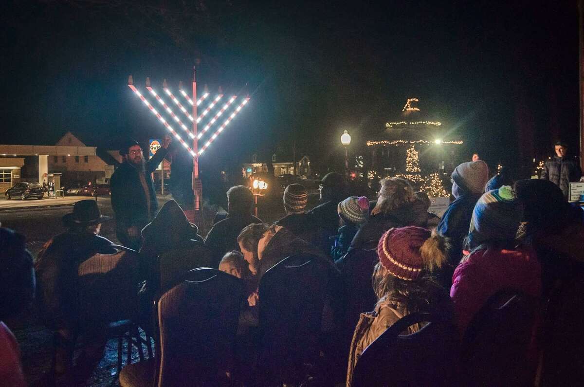 Rabbi Shneur Brook of Chabad of Shelton & Monroe speaks to those gathered at the annual menorah lighting celebration on the Huntington Green on Sunday, Dec. 22, 2019.