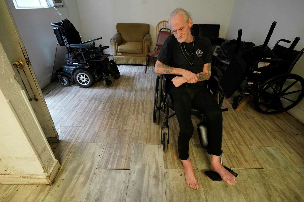 Jim Corsair sits in his apartment Wednesday at Pine Tree Assisted Living in Pasadena. The Texas Health and Human Services Commission issued an order for an emergency closure of the facility due to serious health and safety concerns. He has had multiple strokes and said his can’t tie his shoes, so he goes barefoot. He said he uses his one foot to push himself backward to the facility dinner area.
