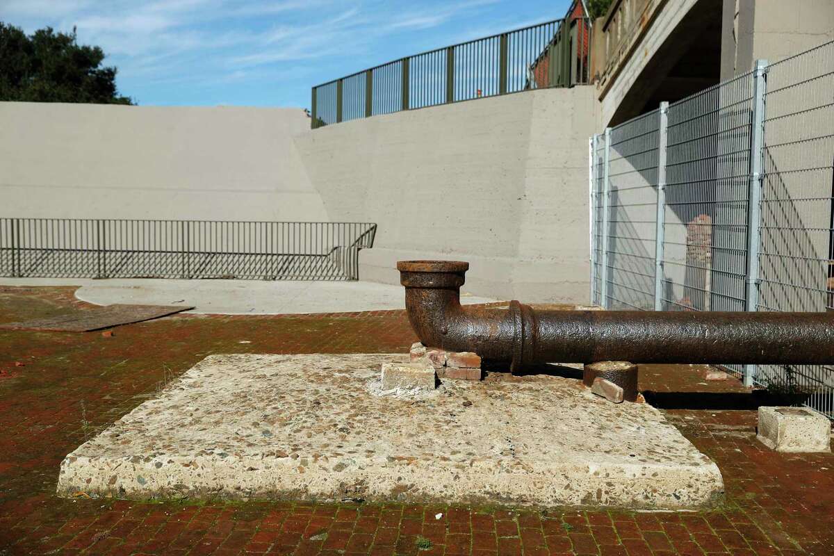 The brick bottom of the tank and the east side wall with a protruding inlet pipe were incorporated into the design to remind visitors that the spot where they sunbathed on the central lawn was once under 12 feet of water.