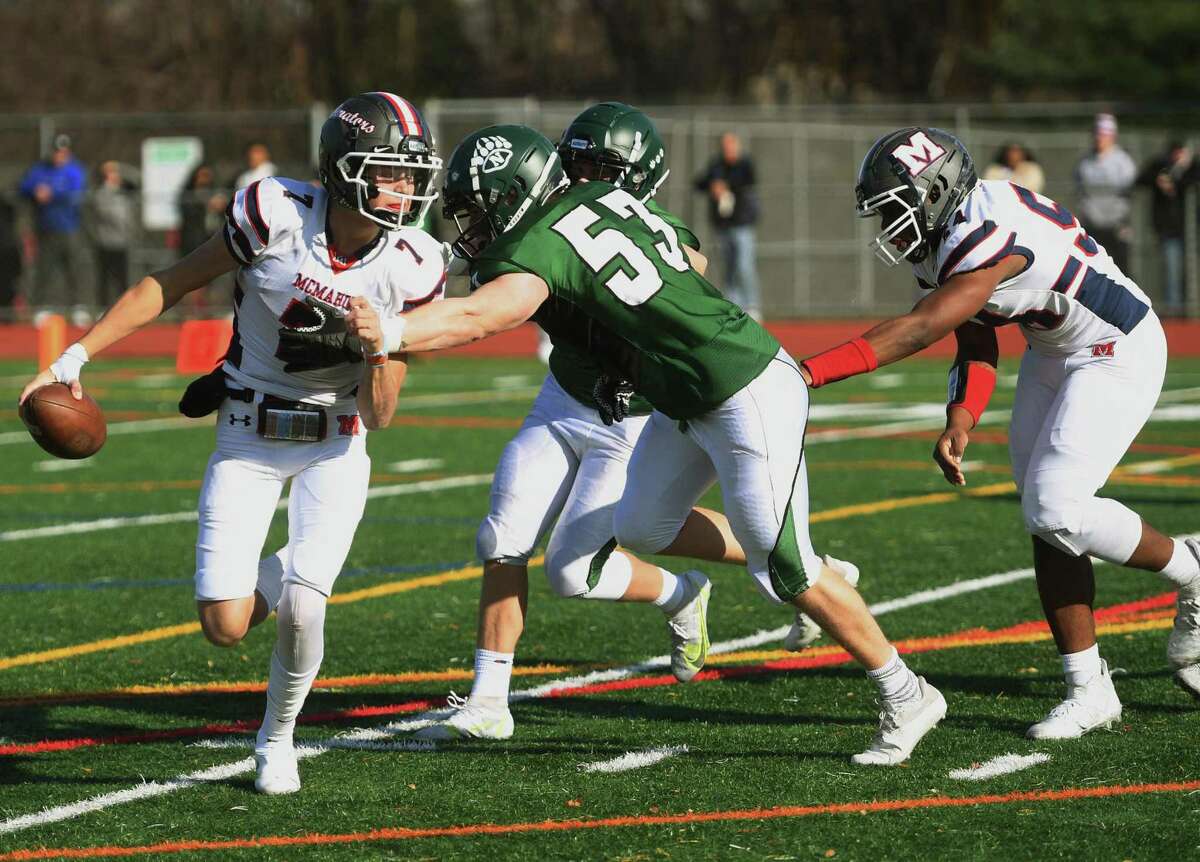 Brien McMahon quarterback Callum Letters is pressured by Norwalk's Brendan Gilchrist during the first half of their annual Thanksgiving Day football game at Norwalk High School in Norwalk, Conn. on Thursday, November 25, 2021.