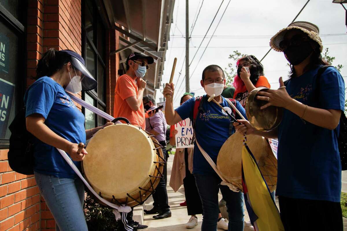 Members of Woori Juntos community group Sihwa Gi, left, Hyunja Norman, center, and Hyunsuk Heo, right, participate in a protest in front of the Harris County Democratic Party offices, Wednesday, Oct. 20, 2021, in Houston.