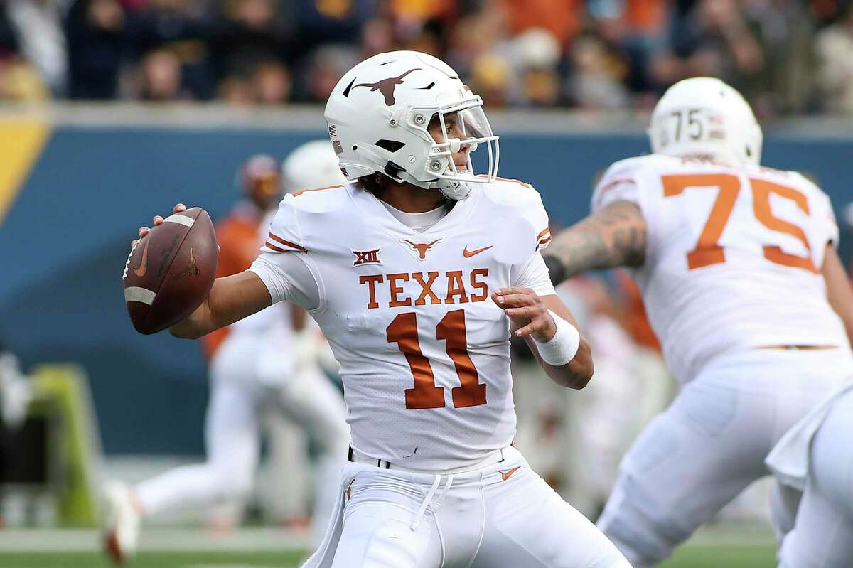 Texas quarterback Casey Thompson (11) passes against West Virginia during the first half of an NCAA college football game in Morgantown, W.Va., Saturday, Nov. 20, 2021. (AP Photo/Kathleen Batten)