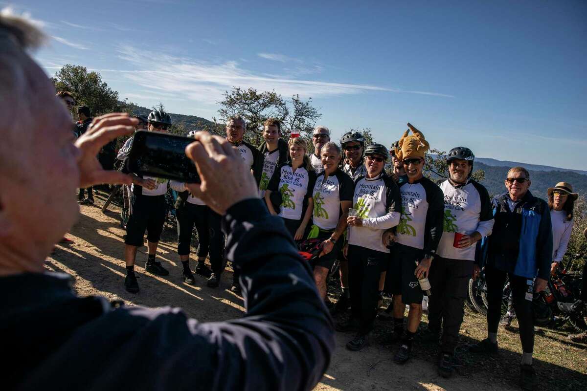Members of the Mountain Bike & Martini Club gather for a group photo during an annual Thanksgiving ride and gathering at Kennedy Trail in Los Gatos.