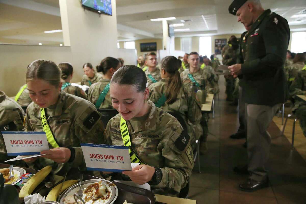 Combat medics in training, Gabrielle Smith 18, left, of Gettysburg, Pennsylvania, and Heather Starr, 19, of Milford, Pennsylvania, read gift cards given out by Maj. Gen. Dennis LeMaster, background, during a Thanksgiving Day meal at Joint Base San Antonio-Fort Sam Houston on Thursday, Nov. 25, 2021. The cards were courtesy of Valero Energy. LeMaster is the commander of the U.S. Army Medical Center of Excellence.