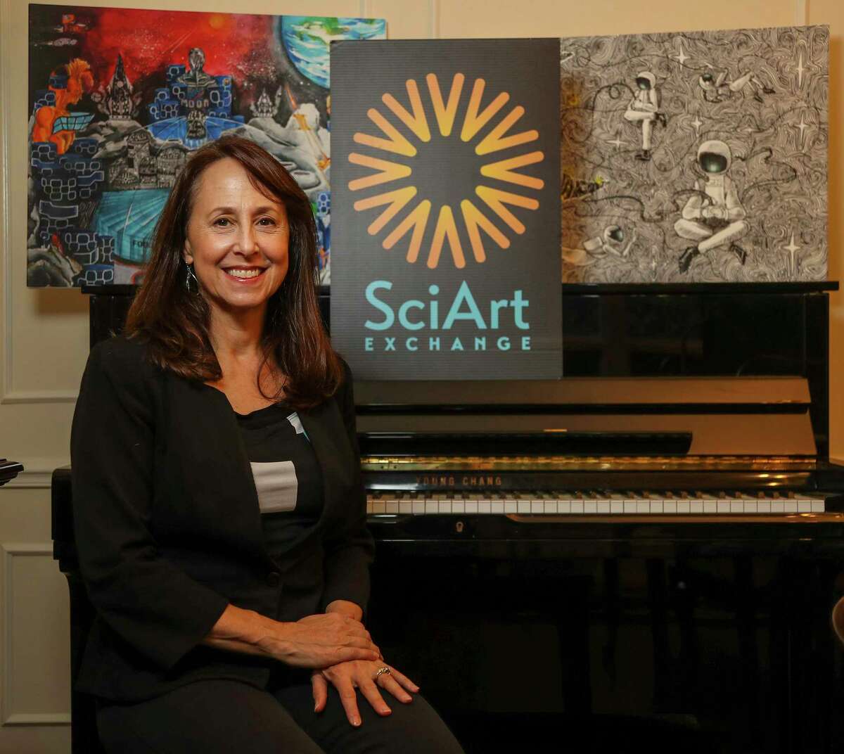 Jancy McPhee, the executive director of SciArt Exchange, with art pieces in her home office, Wednesday, Nov. 17, 2021 in Houston. SciArt Exchange is a Houston organization that offers contests and events to bring together the arts with space, science and technology. It received $1 million from Blue Origin’s foundation Club for the Future this year.