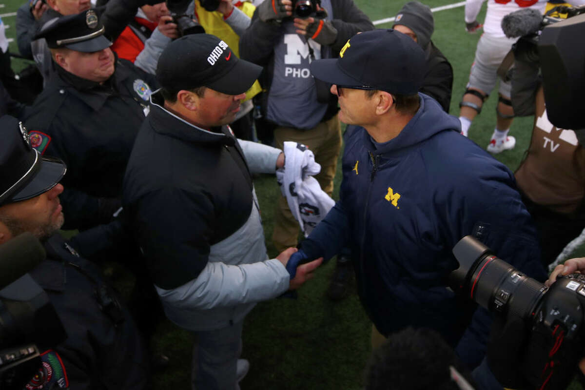 FILE — Head coach Ryan Day of the Ohio State Buckeyes shakes hands with head coach Jim Harbaugh after a 56-27 Ohio State Buckeyes win at Michigan Stadium on November 30, 2019 in Ann Arbor, Michigan.