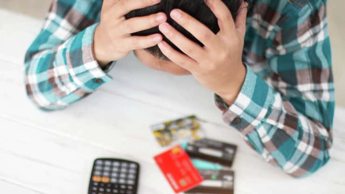 FILE - A man shakes his head over his credit cards. 