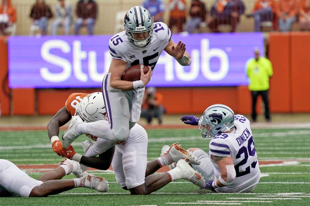 Kansas State quarterback Will Howard (15) is tripped up by Texas linebacker Ovie Oghoufo (18) during the first half of an NCAA college football game in Austin, Texas, Friday, Nov. 26, 2021. (AP Photo/Chuck Burton)