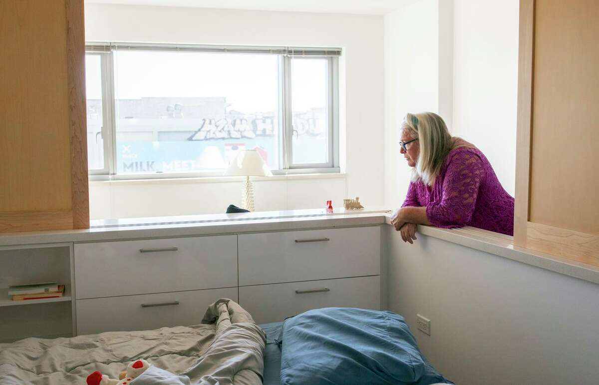 Lori Carpenter takes a moment in her new apartment, Wednesday, Nov. 24, 2021, in San Francisco, Calif. Carpenter was formerly living in a motel provided to people who were homeless. Now she receives visits twice a week from a home care worker who helps her cook and clean. For permanent supportive housing clients who were chronically homeless, the simple services can be the difference between them staying housed and returning to the streets.