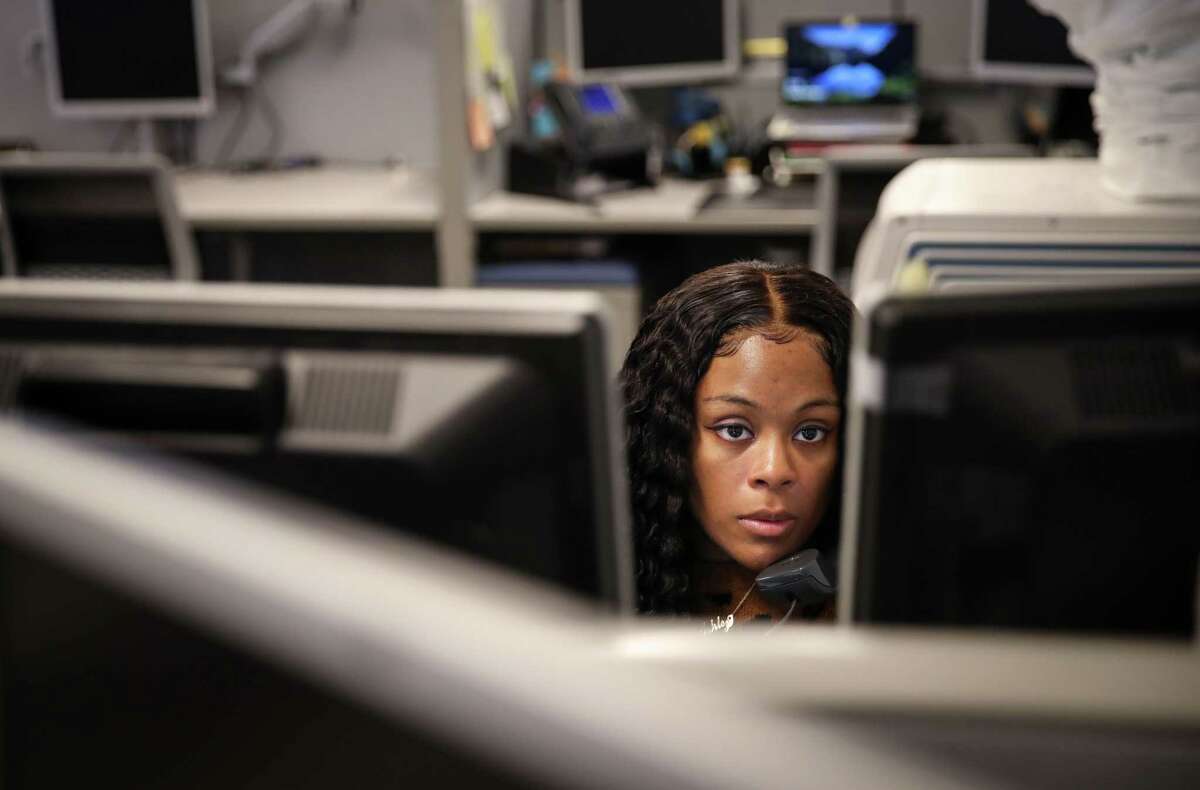 Ashley Williams, a senior 311 telecommunicator, talks with a resident from the city’s 311 call center in Houston. Each operator takes about 100 calls a day.