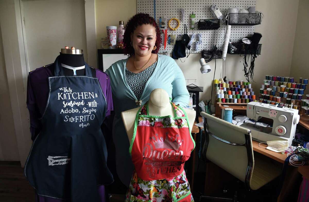 Jennifer Marie Lopez is photographed with holiday aprons that she designed and sewed in her home business office, Jenna Line Customs, in New Haven on November 15, 2021.