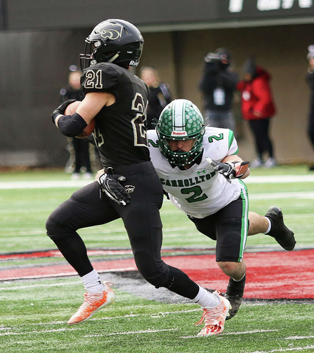 Carrollton's Kyle Leonard (right) tackles Le-Win's Jake Zeal on Friday in the Class 1A football state championship game at Huskie Stadium in DeKalb.