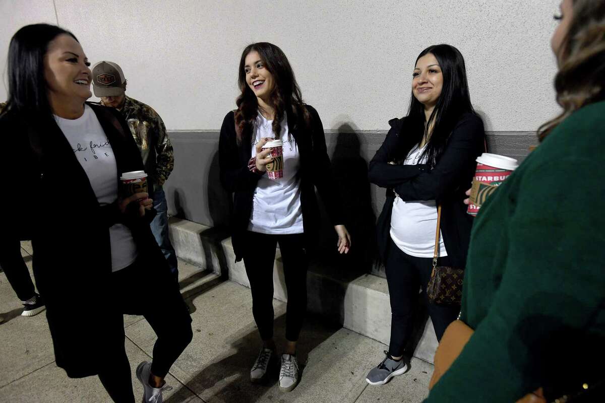 From left, Sarah Dotey, Kayla Crites, Kayla Raggio and Laura Gentile, wearing their matching "Black Friday vibes" t-shirts, talk as they await the opening at Academy Sports + Outdoors on Black Friday. Photo made Friday, November 26, 2021 Kim Brent/The Enterprise