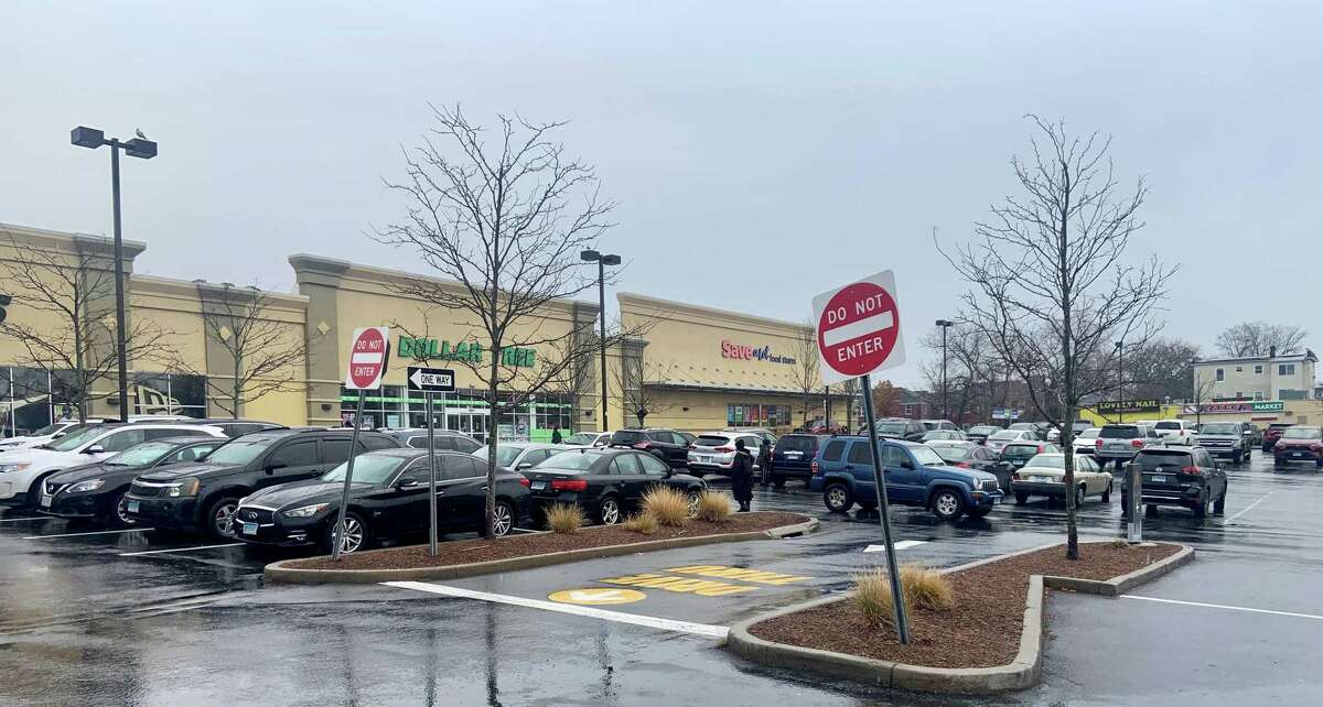 A shopper walks through a parking lot that’s about three-quarters full into the Dollar Tree at the North Park Shopping Center in Bridgeport at about 10:30 a.m. Friday, Nov. 26, 2021.