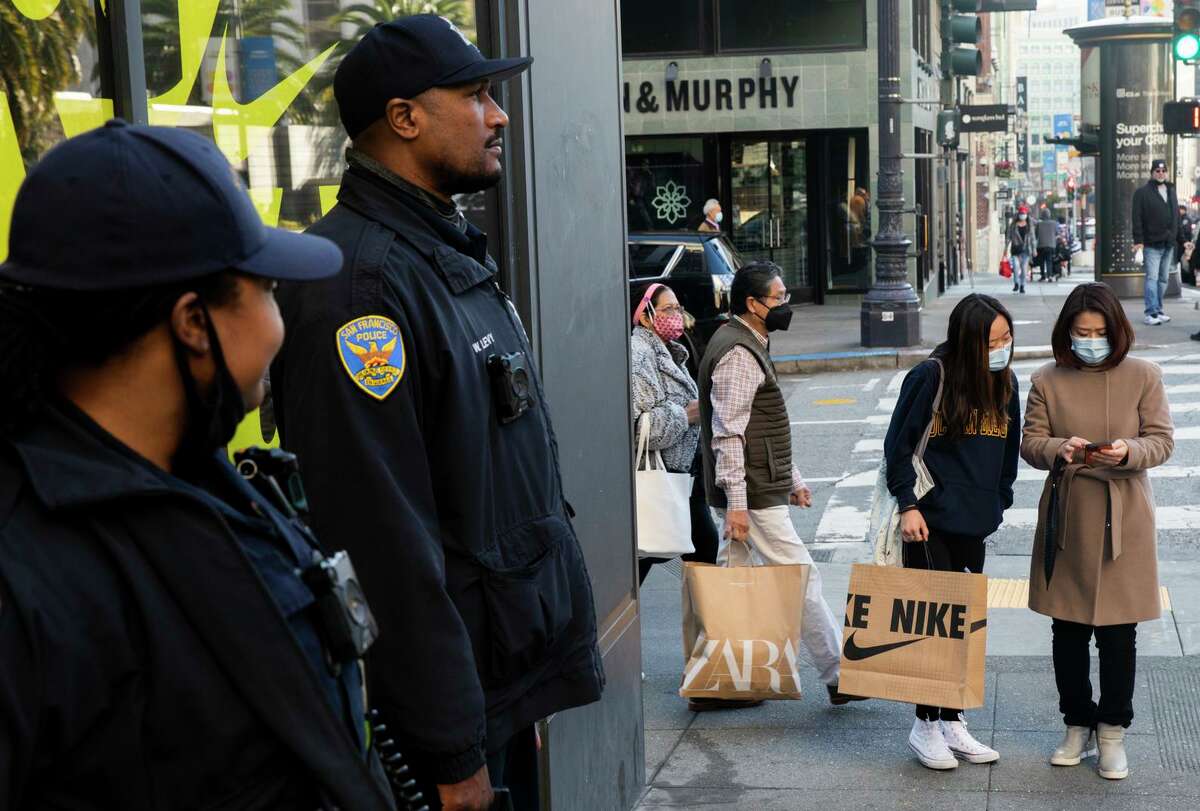 San Francisco Police officers stand guard outside of the Nike store while shoppers search for Black Friday deals at Union Square in San Francisco.