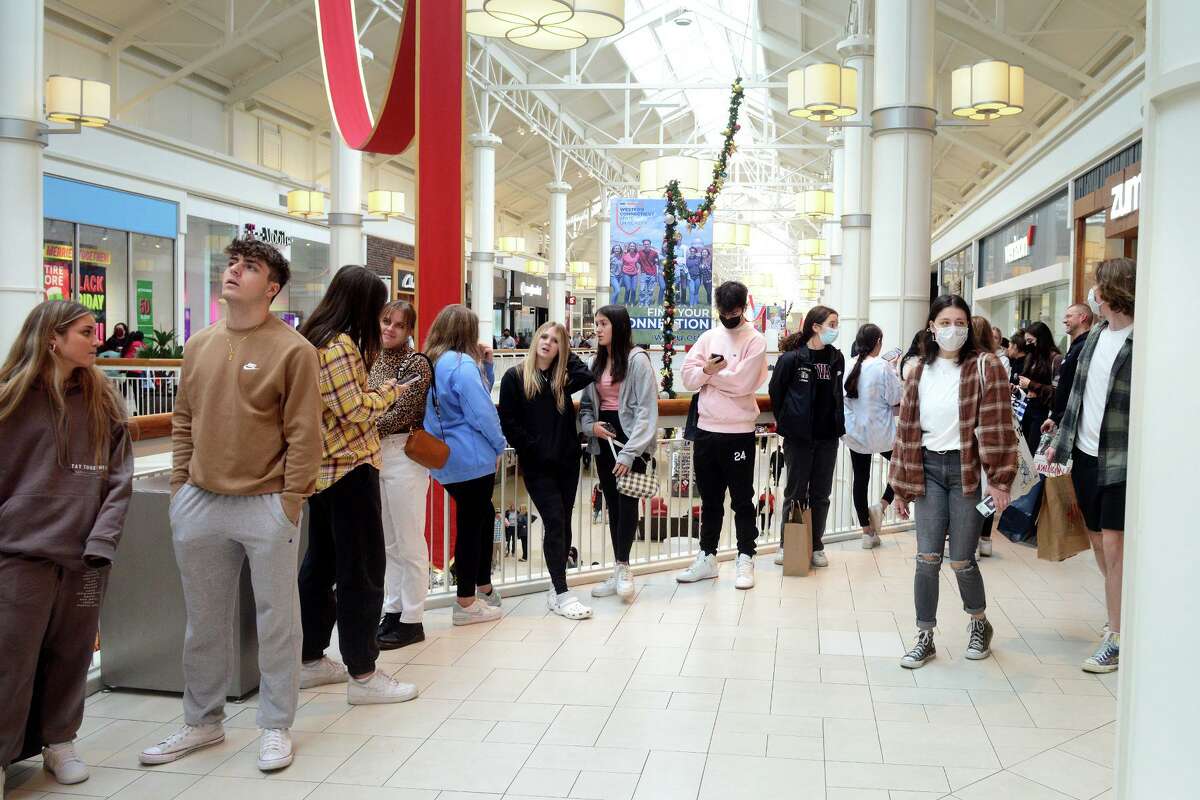Customers wait in line outside a store on Black Friday at Danbury Fair in Danbury, Conn., on Nov. 26, 2021.