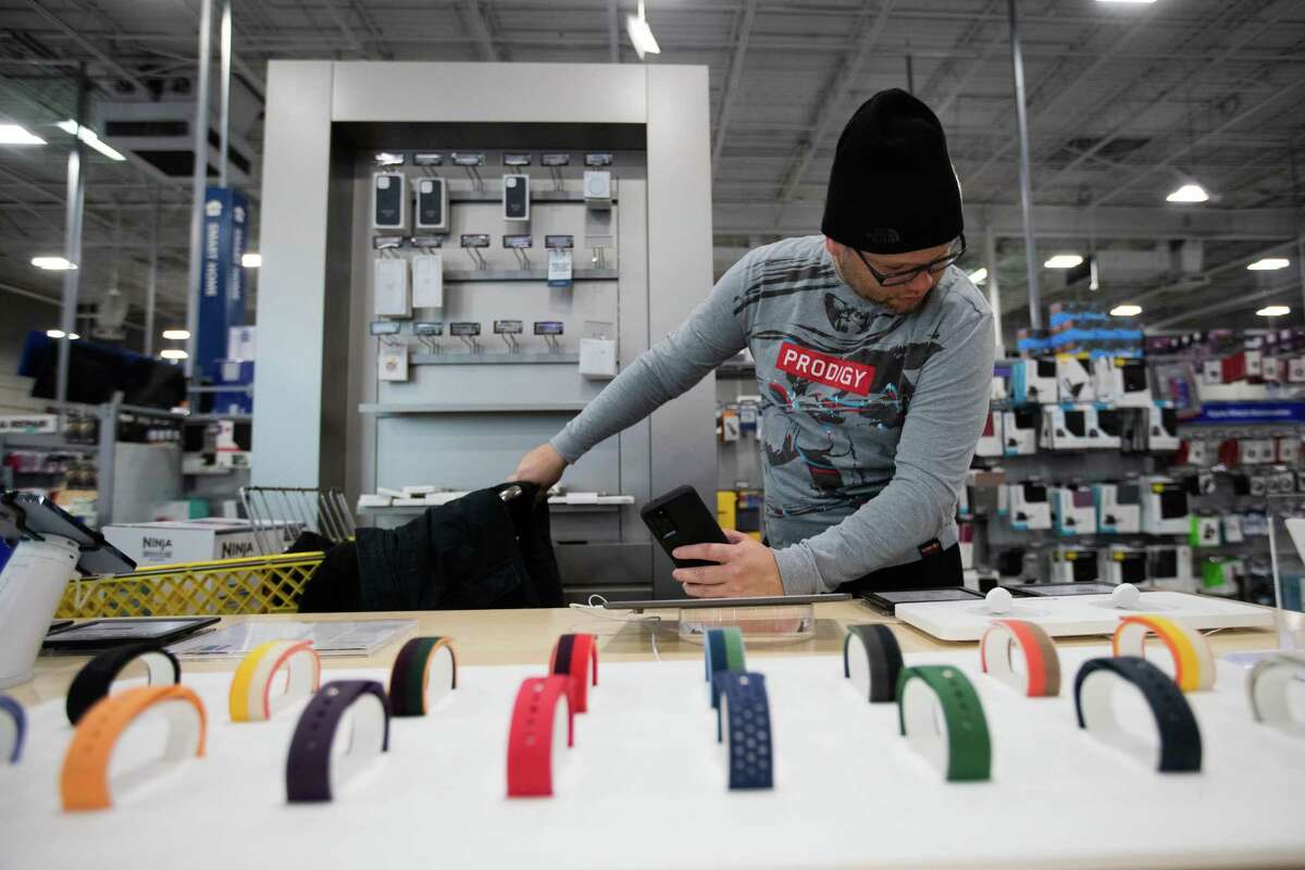 Alfredo Pernia takes a look at Apple products as he shops at Best Buy on Friday in Houston. He says this is his third year of taking advantage of Black Friday deals.