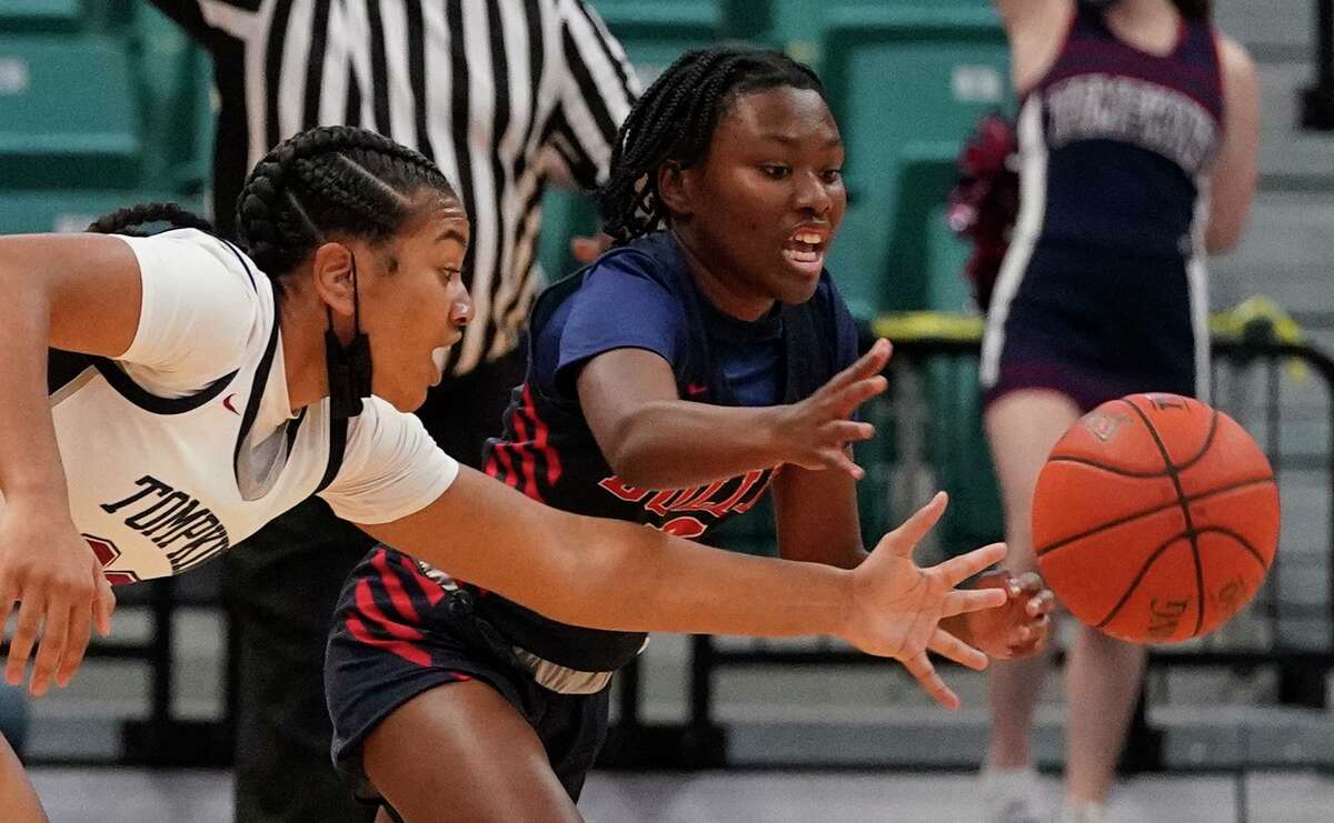 Tompkins Loghan Johnson (23) Dulles Jakiya Thompson (12) reach for a loose ball during girls basketball playoff game at the Merrell Center Wednesday, Feb. 24, 2021 in Katy.