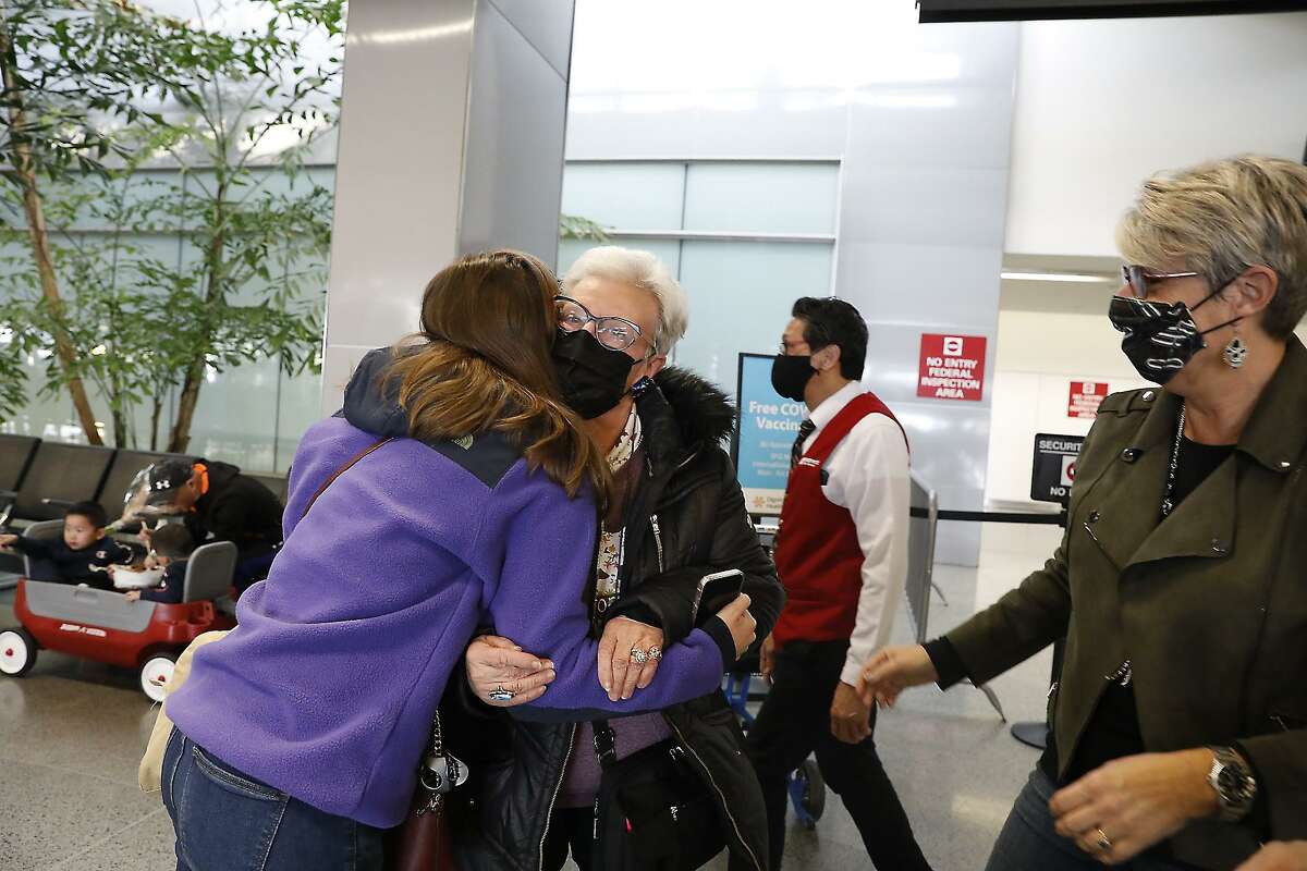 Clemence Parmentier hugs her grandmother Nadine Vallat, whom she hadn’t seen since before the pandemic after Vallat arrived at San Francisco International Airport from Paris.