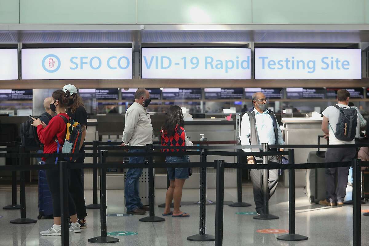 People wait in line at the COVID-19 rapid testing site at the San Francisco International Airport on November 26, 2021. 
