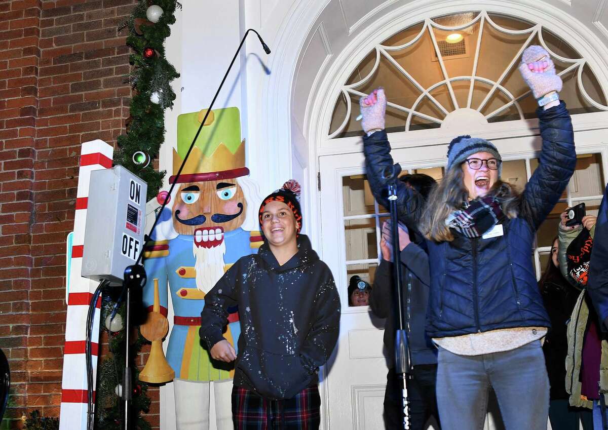 Annie Cozens, right, with the Boys & Girls Club of Ridgefield, lets out a cheer after Logan Hale, right, flips the switch that turned on the holiday lights in downtown. Ridgefield welcomed the holiday season on Nov. 26 with 17,000 lights, songs and a visit from Santa and Mrs. Claus.