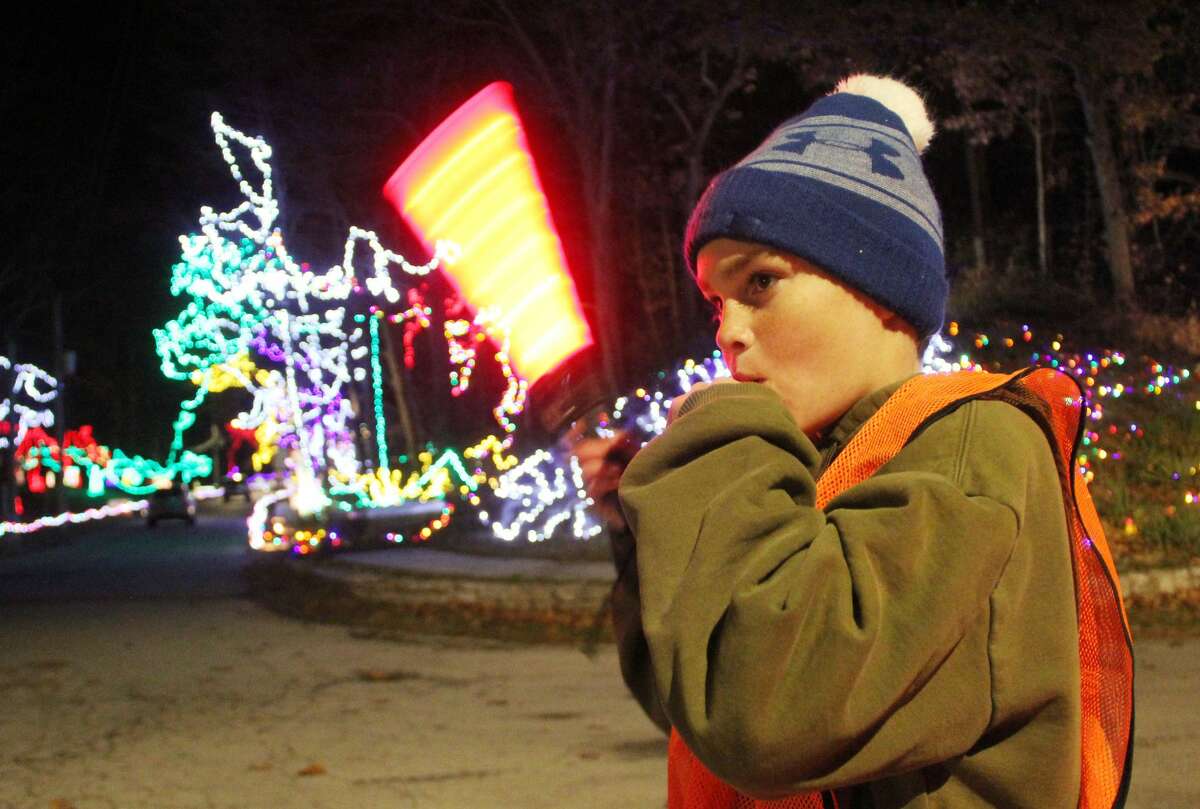 Bodey Waltz, 12, tries to keep his hands warm while directing traffic at the entrance to Christmas Wonderland at Rock Spring Park during opening night on Friday. He was representing the Otter Creek Historical Society, one of the volunteer groups that man the annual display, which runs through Dec. 27.