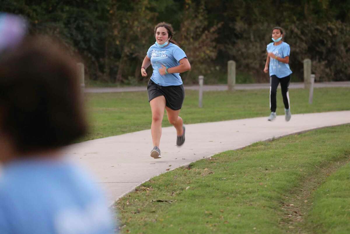 Magali Roibon (center), 13, and Galilea Garza (right), 11, return from a run. A group of girls from Girls on the Run — a nonprofit that focuses on physical activities that instill empowerment, confidence and compassion — gathered for training with their adult female coaches at Olmos Park on Tuesday, Nov. 16. The girls and their team train twice a week, honing skills and adapting lessons learned to complete a 5K run.