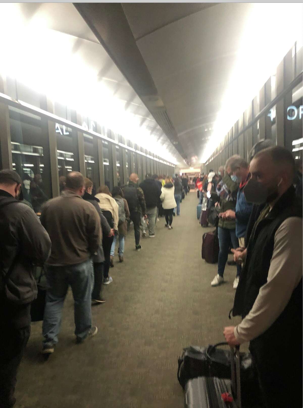 Passengers queue up at Albany International Airport on Sunday, Nov. 28, 2021. Airport officials said long lines are now common during peak periods. They are working on how to address the issue.