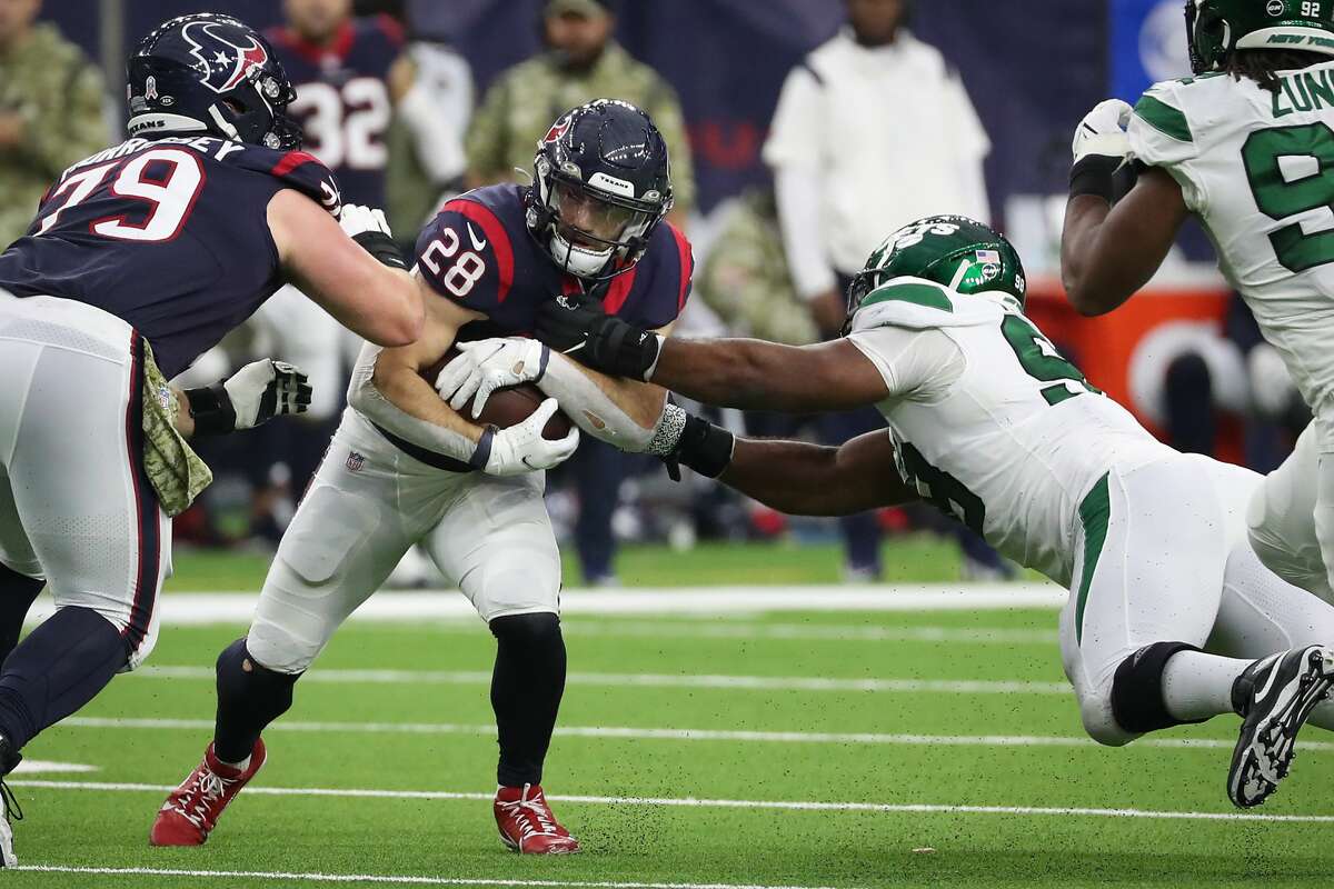 Houston Texans running back Rex Burkhead (28) is stopped for a loss by New York Jets defensive tackle Sheldon Rankins (98) during the third quarter of an NFL football game Sunday, Nov. 28, 2021 in Houston.