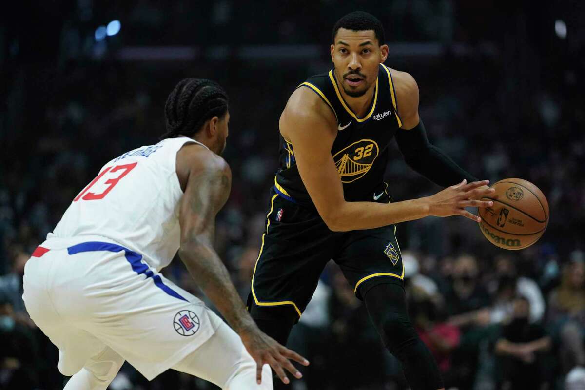 Los Angeles Clippers guard Paul George (13) defends against Golden State Warriors forward Otto Porter Jr. (32) during the first half of an NBA basketball game in Los Angeles, Sunday, Nov. 28, 2021. (AP Photo/Ashley Landis)