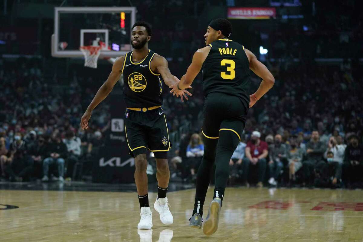 Golden State Warriors forward Andrew Wiggins (22) celebrates with guard Jordan Poole (3) after a point during the first half of an NBA basketball game against the Los Angeles Clippers in Los Angeles, Sunday, Nov. 28, 2021. (AP Photo/Ashley Landis)