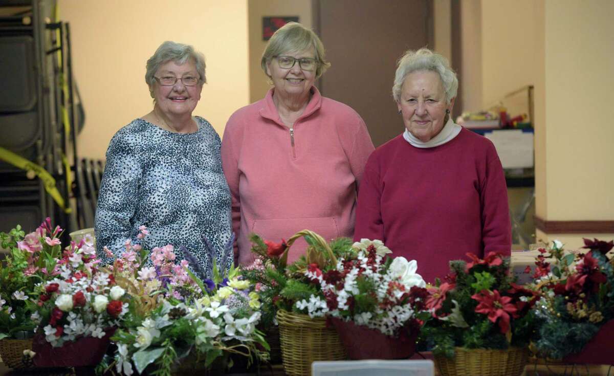 Jacque Petersen, left, Sue Lorpardo and Cindy Gustafson, right, all members of the Sacred Heart Church crafts group, stand with some of the crafts the group has created. Monday, November 22, 2021, Kent Conn.