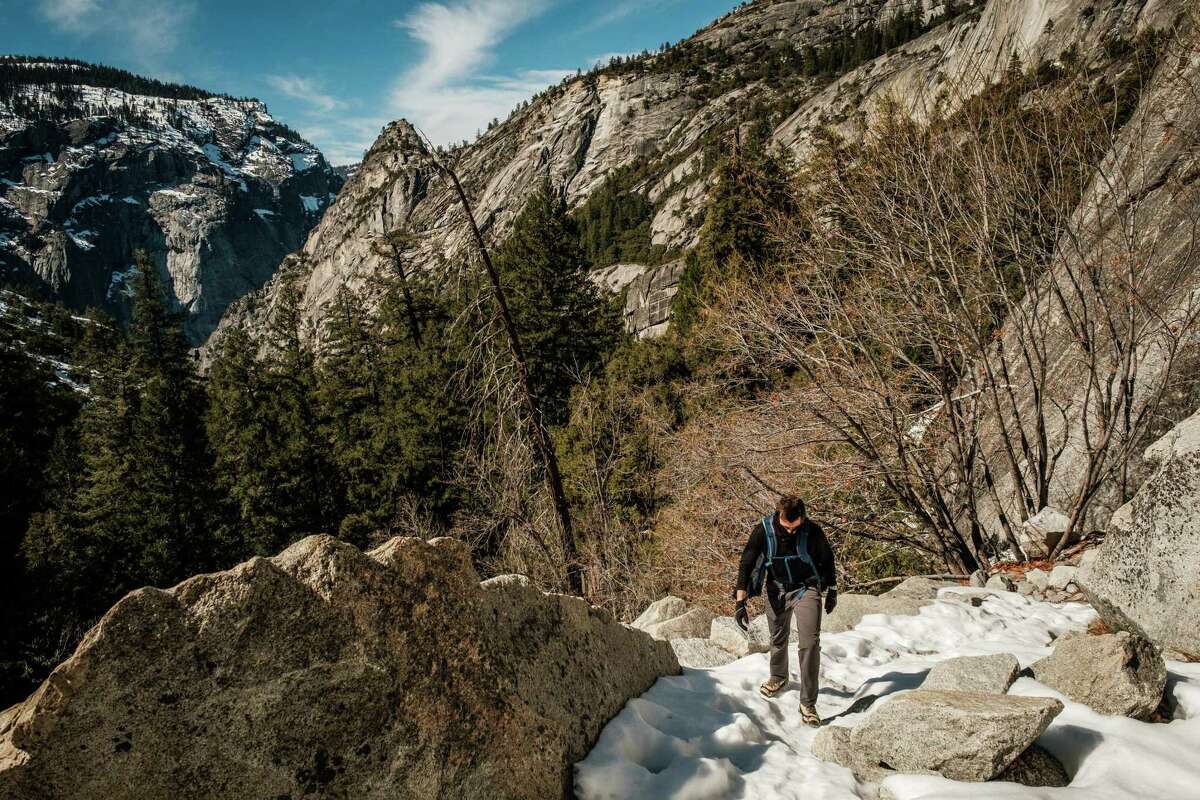 Mark Elmore of Virginia hikes through snow on the Mist Trail in Yosemite National Park in February. With fewer storms, the Sierra is seeing a decline in its snowpack.