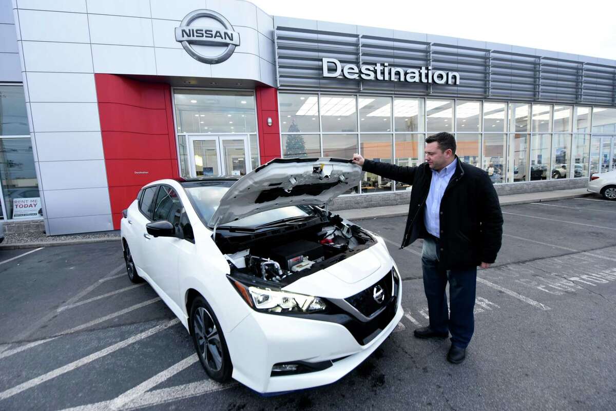 Beau Mayhew, general manager of Destination Nissan, lifts the hood on a 2021 Nissan LEAF electric car on Monday, Nov. 29, 2021, at Destination Nissan on Central Ave. in Albany, N.Y.