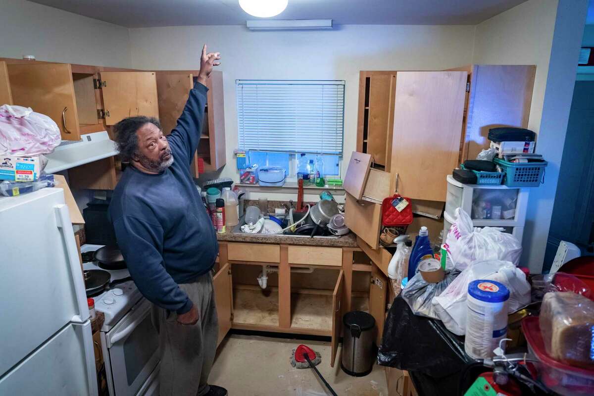 Richard Caudill points at the part of the ceiling where water started pouring into his kitchen after the February freeze, Monday, Nov. 29, 2021, at the Acres Homes Gardens apartments in Houston. Caudill no longer uses his cabinets to store food or goods because he so often sprays for bugs that seemingly infest apartments in the complex. A group of tenants living in the 15-unit apartment building have organized with the Houston Tenants Union and have delivered a demand letter to their landlord asking for timely repairs, pest control and an end to alleged threats and harassment made by management. Management has agreed to meet with tenants.