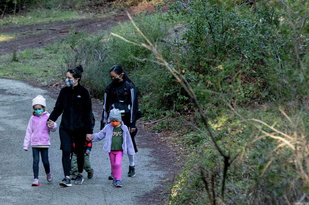 A family wears masks while enjoying the trails at Redwood Regional Park in Oakland, on Dec. 29, 2020.