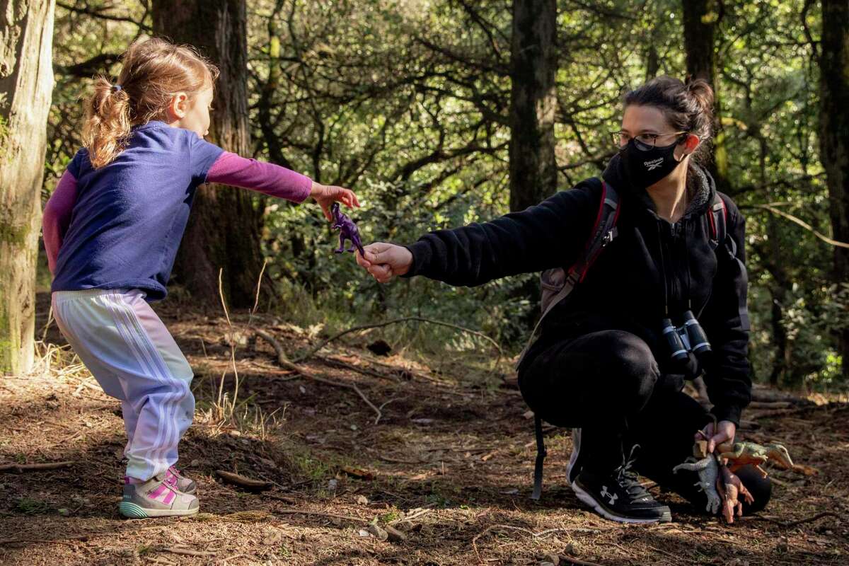 Melanie Richards watches her daughter Charlotte play with toy dinosaurs while enjoying the trails at Redwood Regional Park in Oakland in 2020.
