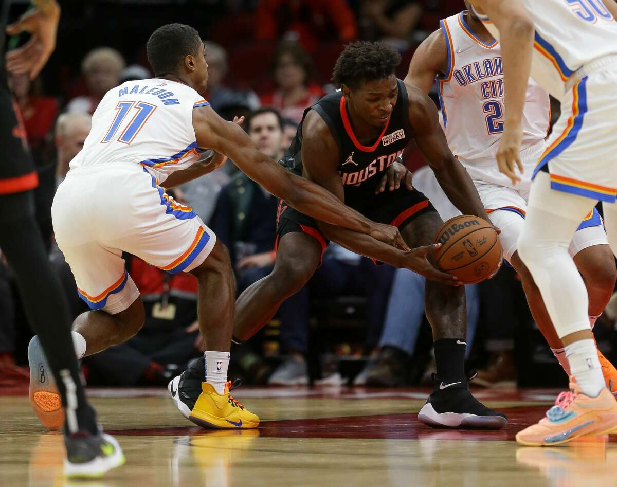 Houston Rockets forward Jae'Sean Tate (8) and Oklahoma City Thunder guard Theo Maledon (11) battle for possession of the ball during the fourth quarter of an NBA game at Toyota Center on Monday, Nov. 29, 2021, in Houston. The Rockets won 102-89.