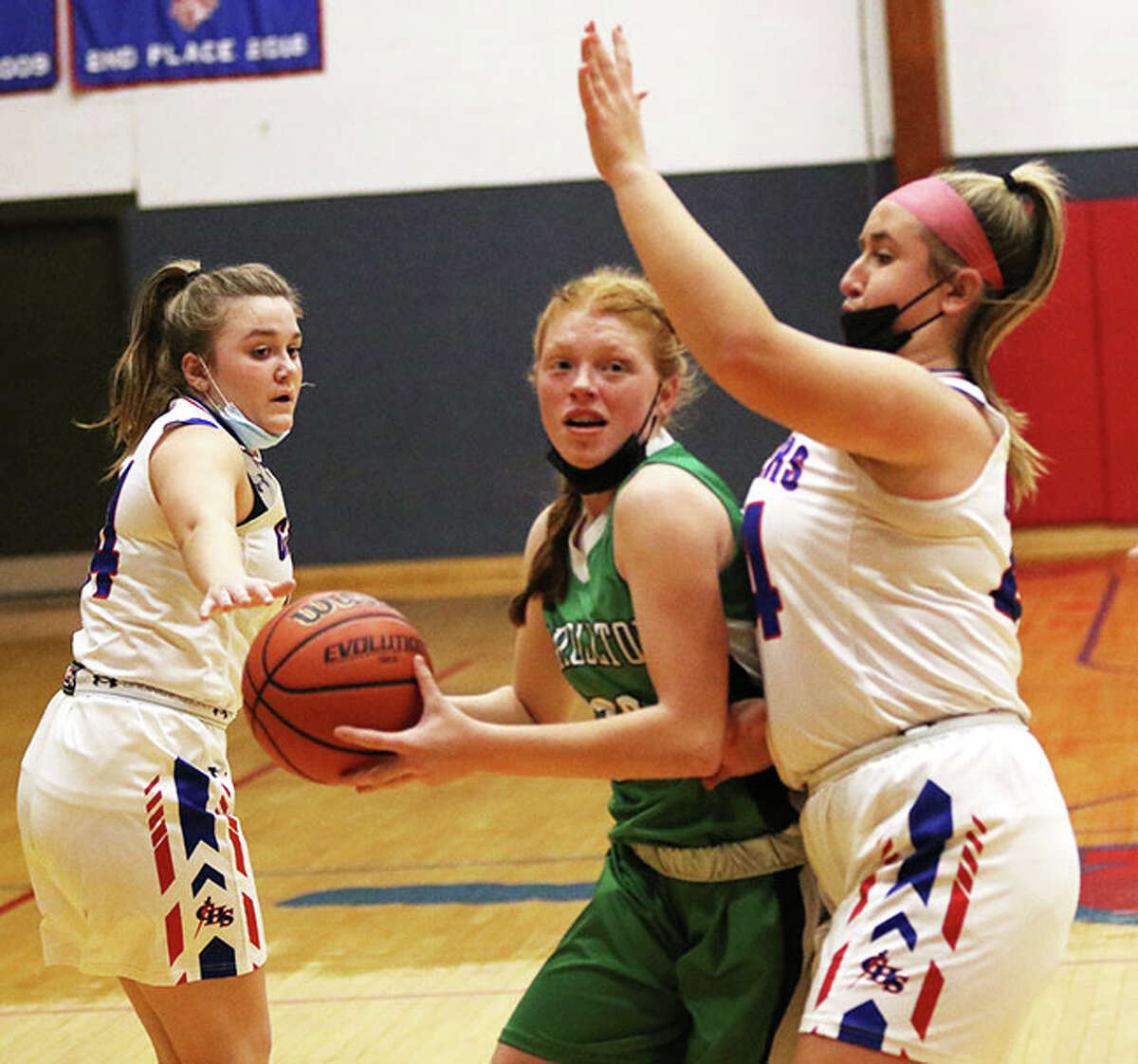 Carrollton's Lauren Flowers, center, scored 22 points and led the Hawks to a 59-33 victory over Triopia Monday. she is shown in previous action against Carlinville.