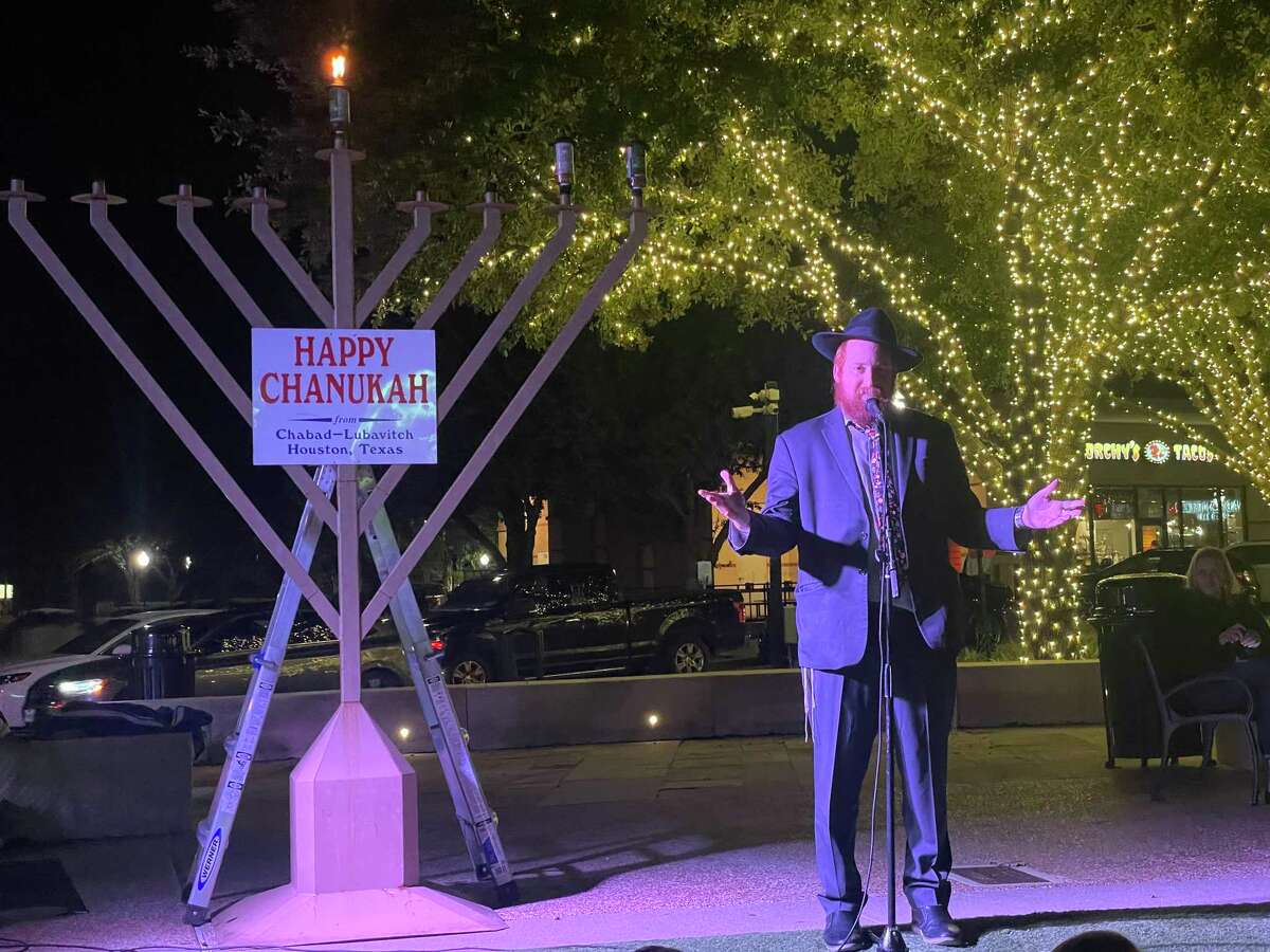 Rabbi Dovid Goldstein speaks while lighting the menorah in LaCenterra on Monday, Nov. 29 2021 in Katy.