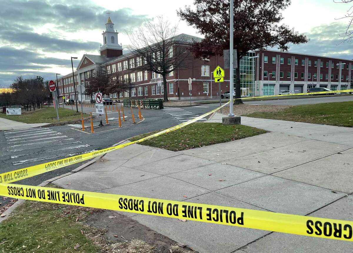 Crime scene tape at a town bus stop near Hamden High School Monday, where police say a student was stabbed.