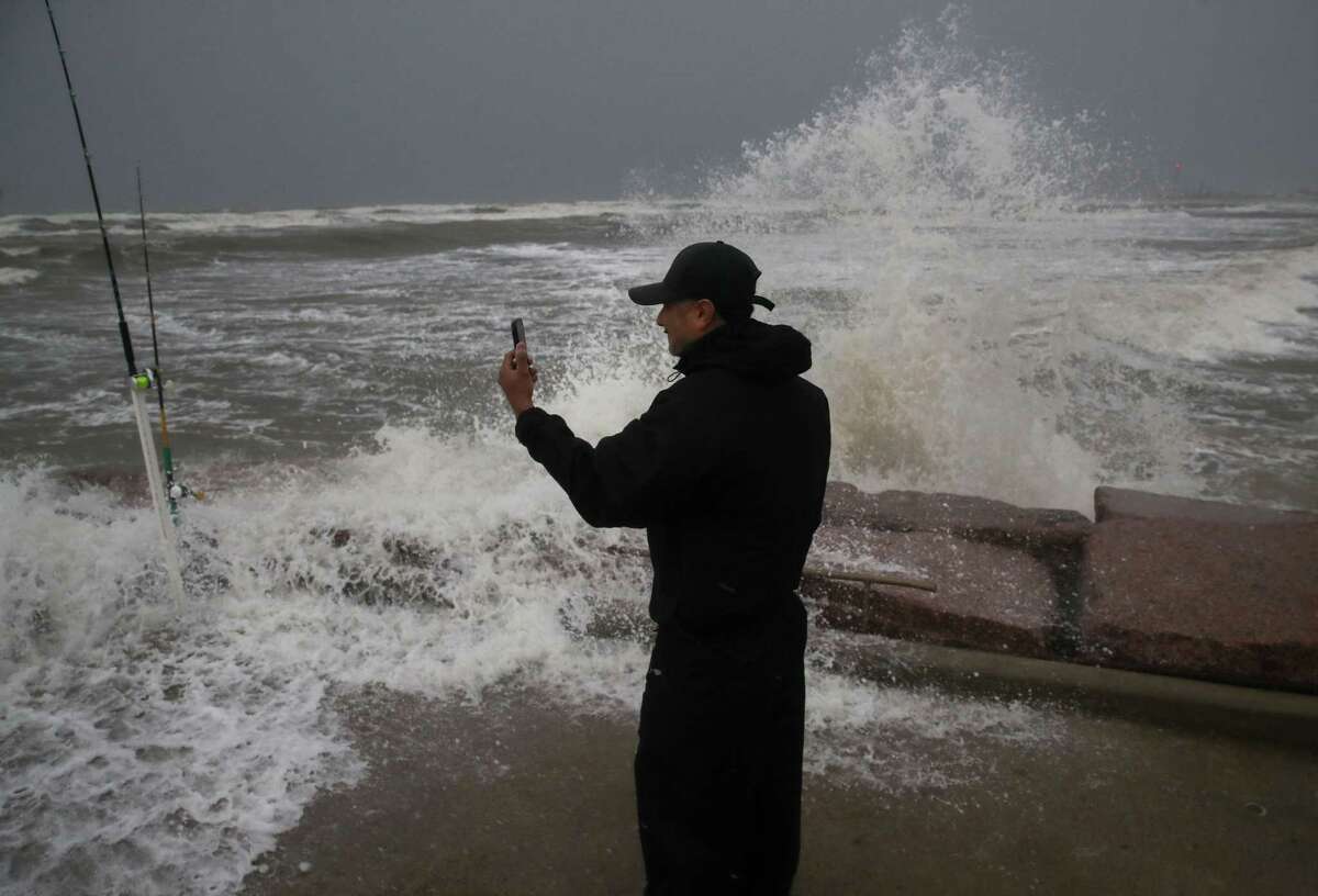 Frank Rivera streams a Facebook live as he fishes with a friend, while Tropical Storm Nicholas heads towards the Texas coast, Monday, Sept. 13, 2021, along the seawall in Galveston.
