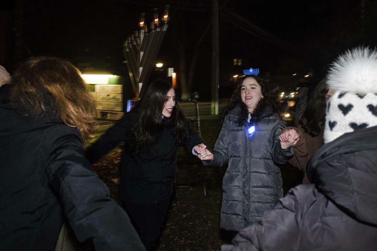 Attendees of the Wilton Menorah lighting, organized by the Chabad Schneerson Center of Jewish Life, dance on the second night of Hanukkah on the Town Green in Wilton, Connecticut. A crowd of around 50 people attended the lighting on Monday, Nov. 29, 2021