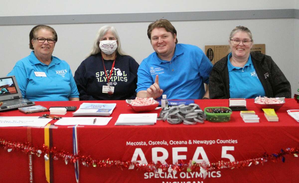 Members of Special Olympics Michigan Area 5, representing Mecosta, Osceola, Oceana and Newaygo counties pose at their booth during Community Giving Day festivities on Tuesday at the Big Rapids Eagles Club 2535.