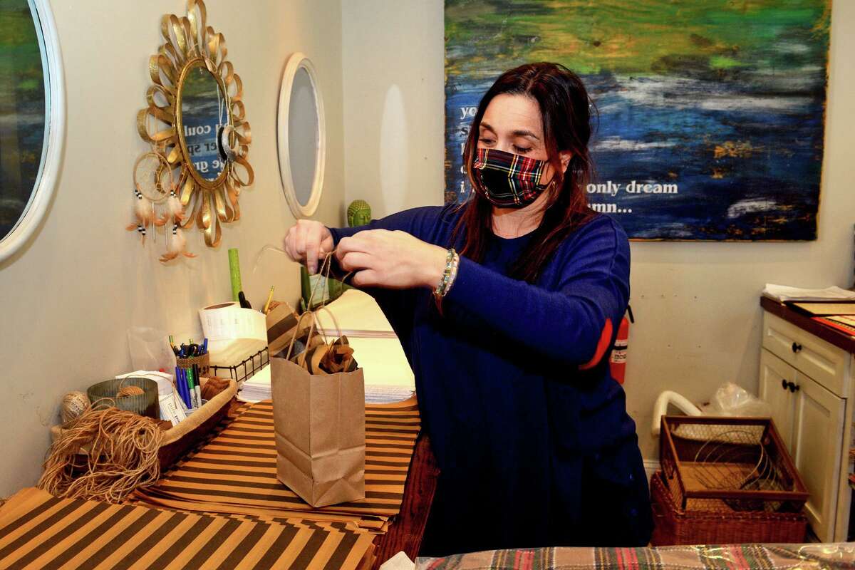 Owner Portia Antonio gift wraps a customer’s purchase at Pure Poetry, in Trumbull on Nov. 29, 2021.