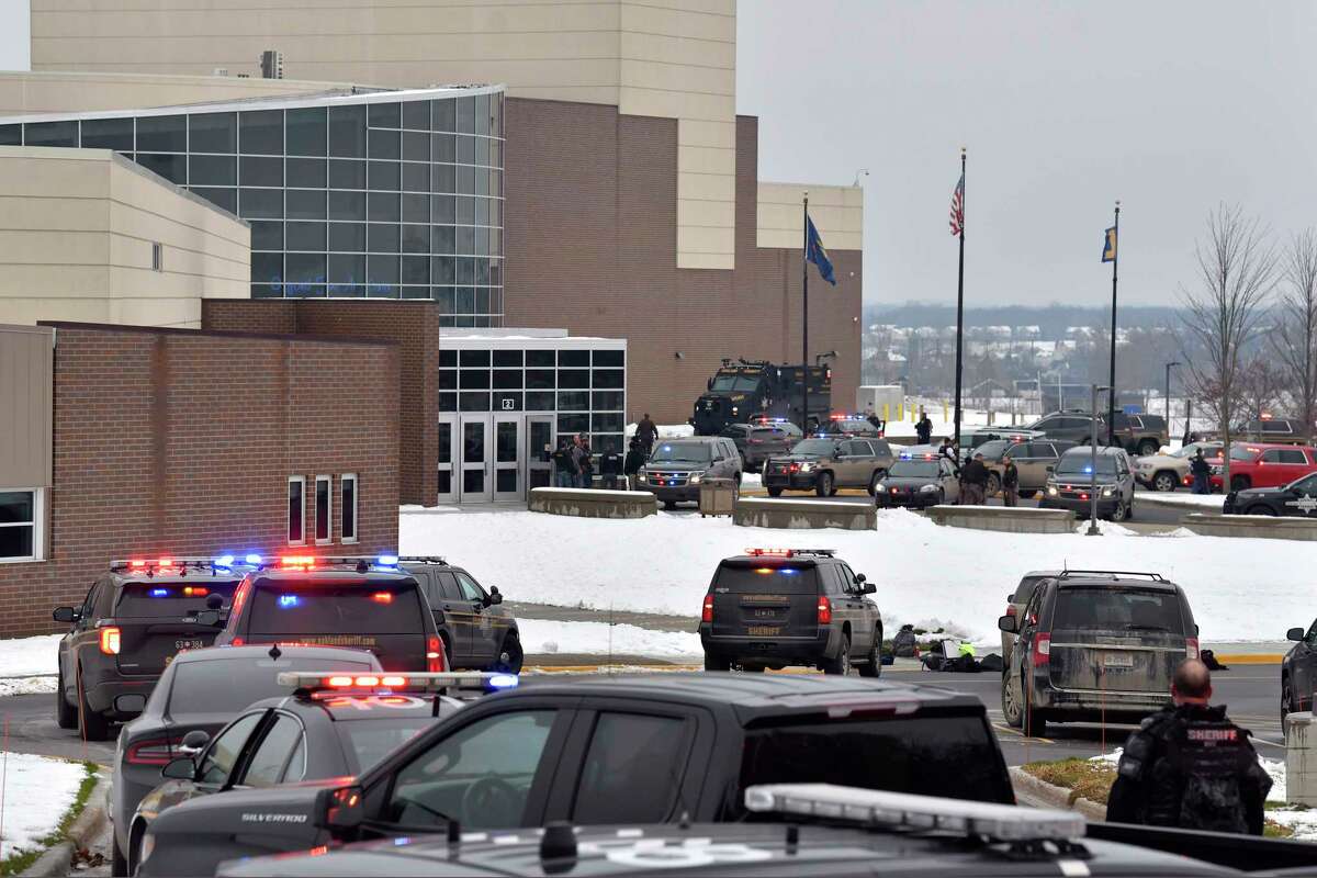 Dozens of police, fire, and EMS personnel work on the scene of a shooting at Oxford High School, Tuesday, Nov. 30, 2021, In Oxford Township, Mich. (Todd McInturf/The Detroit News via AP)
