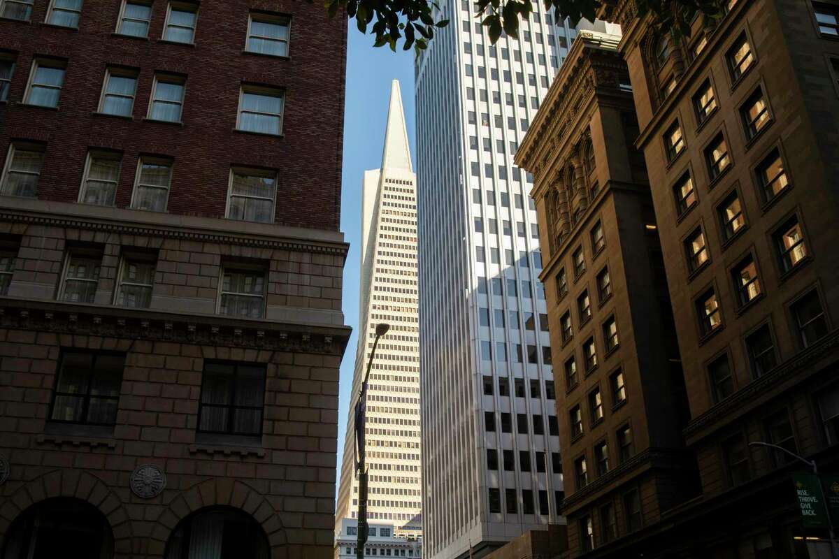 The Transamerica Pyramid peeks through tall towers along California Street in the Financial District of San Francisco.