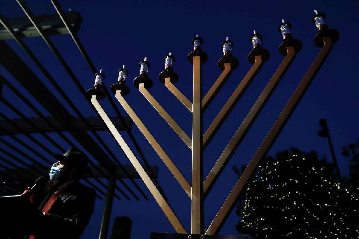 Rabbi Mendel Blecher speaks during the annual menorah lighting to celebrate Hanukkah at Market Street, Thursday, Dec. 17, 2020, in The Woodlands. For the last decade, Chabad of The Woodlands has held the event to celebrate the Jewish holiday tradition as a community-wide celebrate, which features a nine-foot, seven-branched menorah.