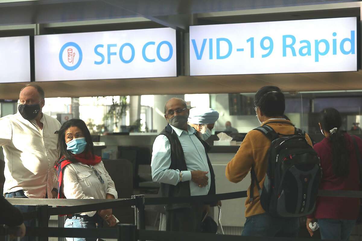 People are seen waiting in line at the COVID-19 rapid testing site at the San Francisco International Airport on Friday.