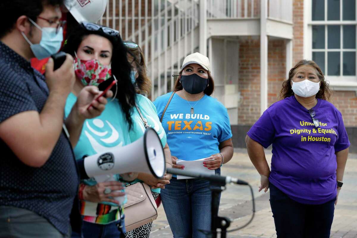 Supporters, right, listen to speakers during a rally of some 20 supporters to demand passage of an essential workers board to advocate for workplace health and safety Tuesday, Oct. 26, 2021 outside of the Harris County Commissioner’s Court building in Houston, TX.